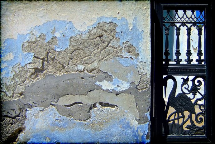 weathered wall and iron gate santorini greece